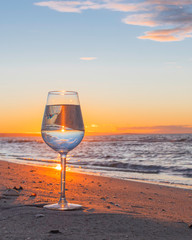 Reflet dans un verre au coucher du soleil sur une plage.
