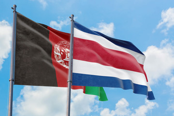 Fototapeta na wymiar Costa Rica and Afghanistan flags waving in the wind against white cloudy blue sky together. Diplomacy concept, international relations.