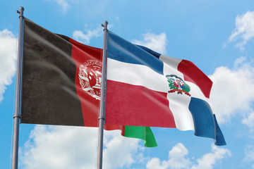 Dominican Republic and Afghanistan flags waving in the wind against white cloudy blue sky together. Diplomacy concept, international relations.