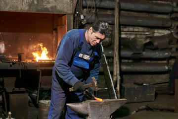 mature male blacksmith at work