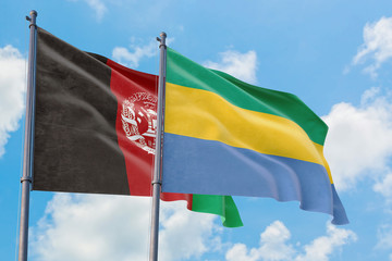 Gabon and Afghanistan flags waving in the wind against white cloudy blue sky together. Diplomacy concept, international relations.