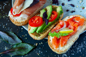 Appetizing bruschetta. Traditional Italian bruschetta. Open sandwich with salmon and vegetables. Delicious healthy food. European cuisine. 