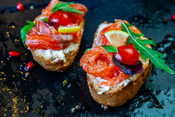 Appetizing bruschetta. Traditional Italian bruschetta. Open sandwich with salmon and vegetables. Delicious healthy food. European cuisine. 