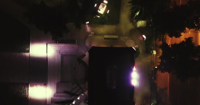 Top view park at the night flying smoothly thru pathways calm and empty place behind roads and buildings [4K4096x2160] 23,976fps