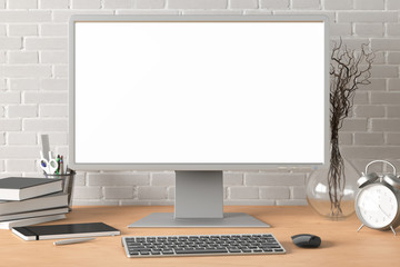 Workspace with blank computer monitor white screen mock up on the wooden desk near white brick wall. monitor; screen; computer; mock up;