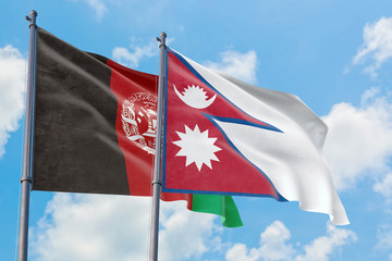 Nepal and Afghanistan flags waving in the wind against white cloudy blue sky together. Diplomacy concept, international relations.