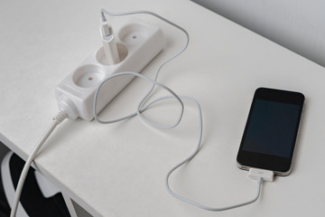 a socket with a phone wire quick charger on the white shelf
