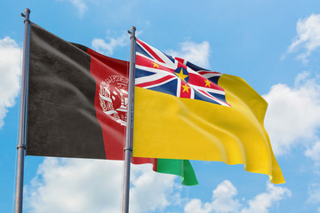 Niue and Afghanistan flags waving in the wind against white cloudy blue sky together. Diplomacy concept, international relations.