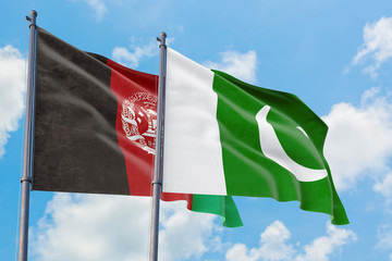 Pakistan and Afghanistan flags waving in the wind against white cloudy blue sky together. Diplomacy concept, international relations.