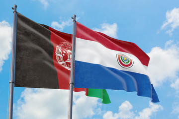 Paraguay and Afghanistan flags waving in the wind against white cloudy blue sky together. Diplomacy concept, international relations.