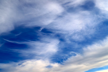 Naklejka na ściany i meble Beautiful picturesque unusual white feather clouds in the blue sky, background. fantastic white clouds. Landscape background, climate change, global warming