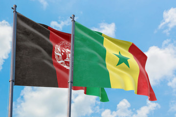 Senegal and Afghanistan flags waving in the wind against white cloudy blue sky together. Diplomacy concept, international relations.