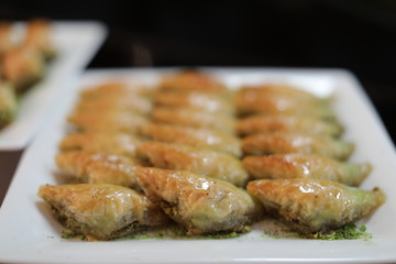 Close up of traditional oriental sweet pastry cookies known as backlava, Turkish desert with sugar, honey, walnuts and pistachio