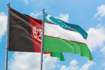 Uzbekistan and Afghanistan flags waving in the wind against white cloudy blue sky together. Diplomacy concept, international relations.