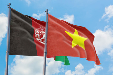 Vietnam and Afghanistan flags waving in the wind against white cloudy blue sky together. Diplomacy concept, international relations.