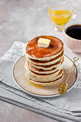 Healthy and delicious breakfast: coffee and stack of classic american pancakes with butter and honey