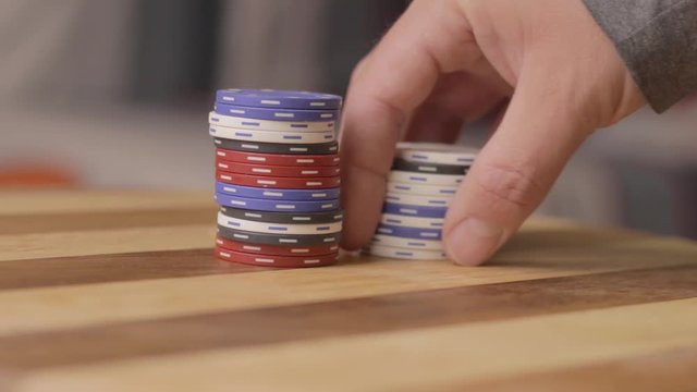 static of a man removing stack of poker chips
