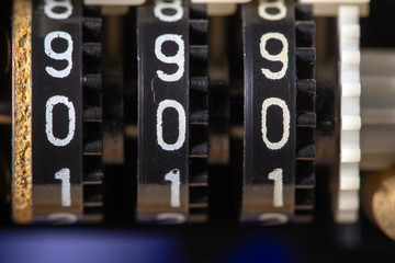 Old three-position mechanical counter with zero digits, low shallow focus