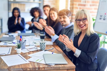 Group of business workers smiling happy and confident. Working together with smile on face looking at the camera applauding at the office