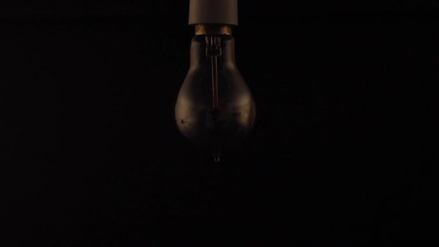 Retro Style Filament Lightbulb Flickering In Slowmotion.