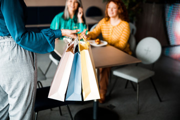 Obraz na płótnie Canvas Woman holding shopping bags and meeting friends