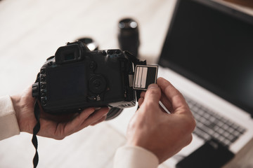 photographer man hand SD card with camera on desk