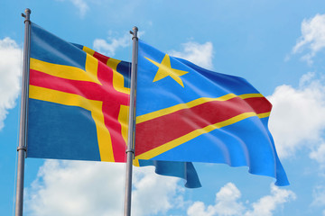 Congo and Aland Islands flags waving in the wind against white cloudy blue sky together. Diplomacy concept, international relations.