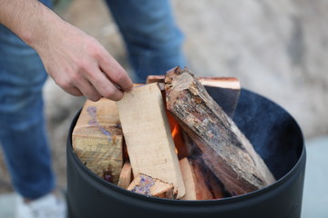 close up a guy hand is trying to start a fire with woods