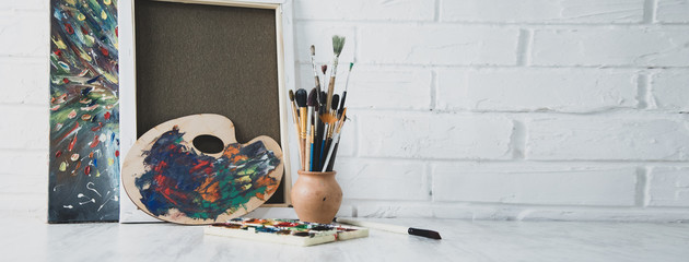 brushes with canvas on brick wall background