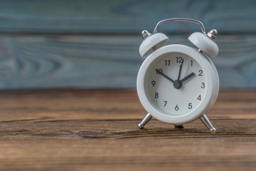 White alarm clock on a wooden background