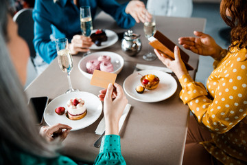 Three ladies paying for order in cafe