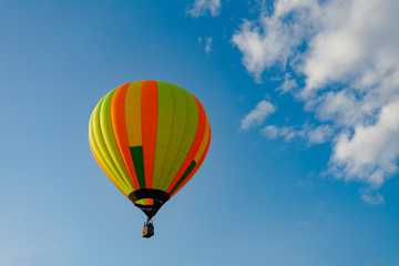 Fototapeta na wymiar Colorful hot air balloons flying in blue sky. Few colorful, hot air balloons descending at the Balloon Festival.
