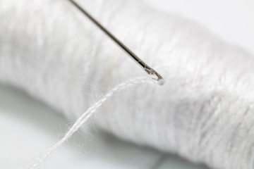 Close up White sewing thread with an embroidery needle. Crafts and DIY concepts
