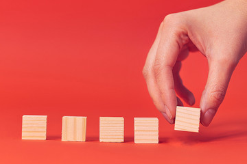 Row blank wooden blocks on a red background with copyspace for your text, letters or numbers.