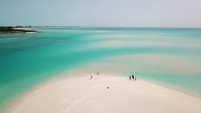 People on a white sandy beach in Providenciales in the Turks and Caicos archipelago. High angle aerial