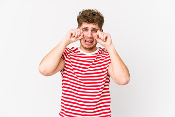 Fototapeta premium Young blond curly hair caucasian man isolated crying, unhappy with something, agony and confusion concept.