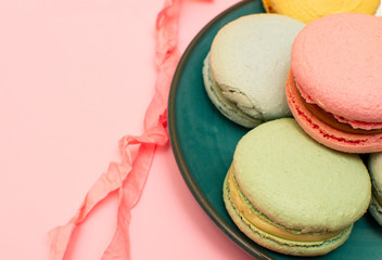 Fresh bright colored macaroons, or macaroons on a colored plate, on a pink background