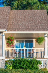 A perfect neighborhood. Houses in suburb at Summer in the north America. Fragment of a luxury house with nice window over blue and white sky.