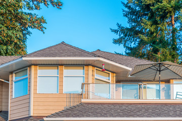 A perfect neighborhood. Houses in suburb at Summer in the north America. Top of a luxury house with nice window over blue and white sky.