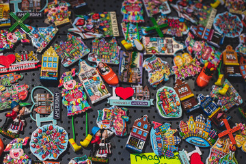 Traditional souvenirs from Amsterdam - fridge magnets, rows of Delftware porcelain, Dutch style houses, dutch wooden clogs, wooden tulips and windmill miniature, shop window store front, Netherlands