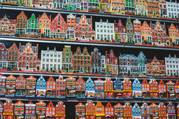 Traditional souvenirs from Amsterdam - fridge magnets, rows of Delftware porcelain, Dutch style houses, dutch wooden clogs, wooden tulips and windmill miniature, shop window store front, Netherlands