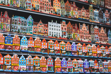 Traditional souvenirs from Amsterdam - fridge magnets, rows of Delftware porcelain, Dutch style houses, dutch wooden clogs, wooden tulips and windmill miniature, shop window store front, Netherlands