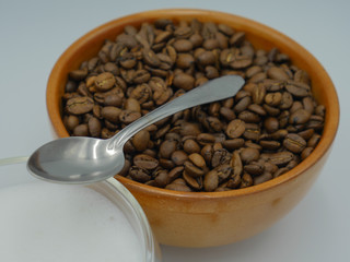 Coffee beans spoon towards a latte macchiato