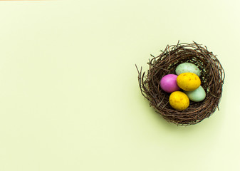 Easter eggs in a nest on a yellow background
