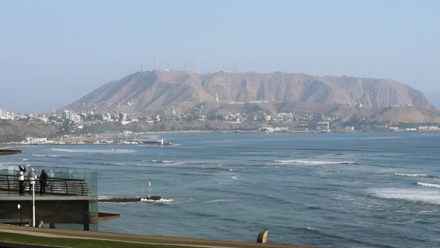 Beautiful Cinematic View of People looking at Miraflores, Lima, Peru Skyline with Mountain and Ocean in the Background
