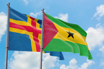 Sao Tome And Principe and Aland Islands flags waving in the wind against white cloudy blue sky together. Diplomacy concept, international relations.