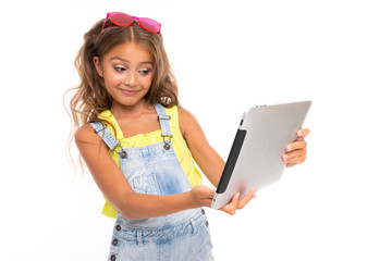 Stylish girl with long fair hair looks cartoon or film on the tablet