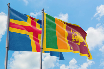 Sri Lanka and Aland Islands flags waving in the wind against white cloudy blue sky together. Diplomacy concept, international relations.