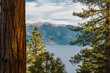 A red helicopter flies over Lake Tahoe near Crystal Bay