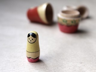 Wooden Russian matryoshka dolls in folk style, girls with painted dresses and veiled heads covered with babushka shawl. A little girl is lost, alone and frightened